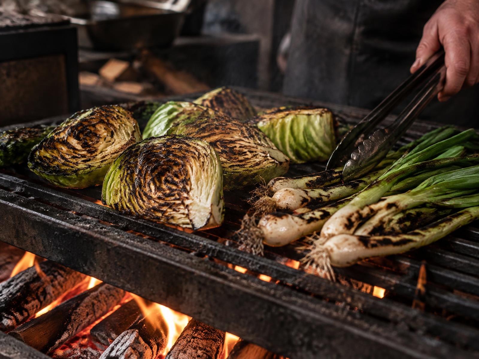 Cabbages and spring onions charring above the open fire